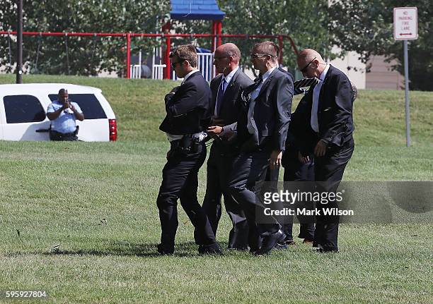 Members of the U.S. Secret Service turn away from the prop wash as Marine One carrying U.S. President Barack Obama arrives at Walter Reed National...