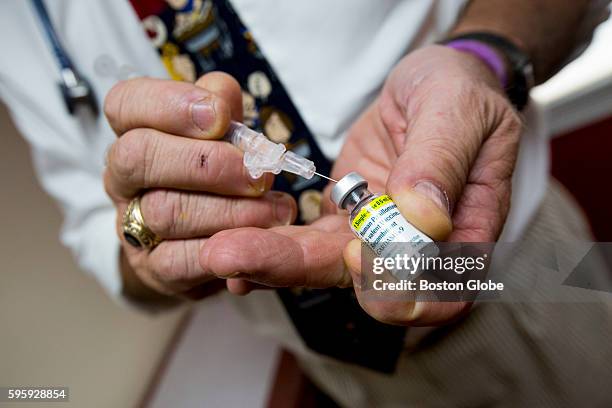 Pediatrician Richard K. Ohnmacht prepares a shot of the HPV vaccine Gardasil for a patient at his office in Cranston, Rhode Island, Sept. 3, 2015....