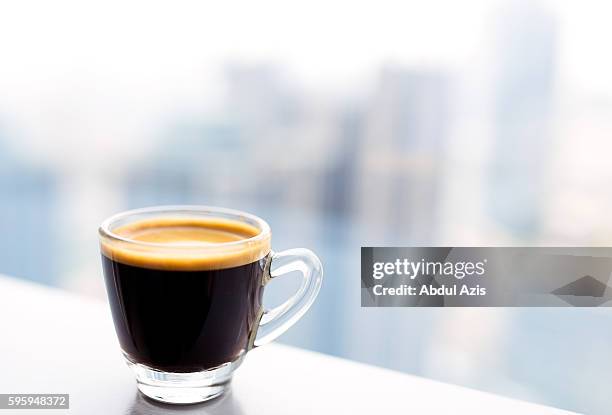 tiny glass cup of espresso coffee - espresso stockfoto's en -beelden