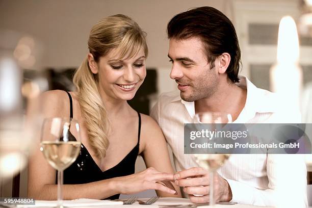young woman having a ring put on her finger - wine glass finger food stock-fotos und bilder