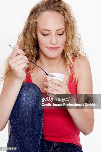 young woman holding a tub of natural yoghurt in her hand - yoghurt tub stock pictures, royalty-free photos & images