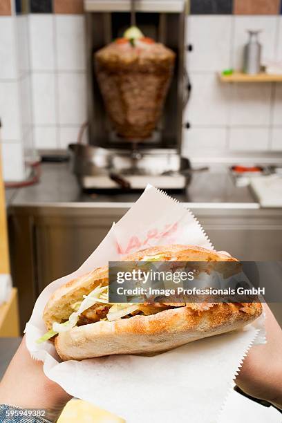 hands holding a d??ner kebab in a snack bar - doner kebab stock pictures, royalty-free photos & images