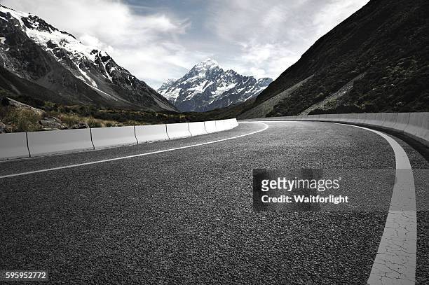 asphalt road with snow mountain background. - nieuw zeelandse alpen stockfoto's en -beelden