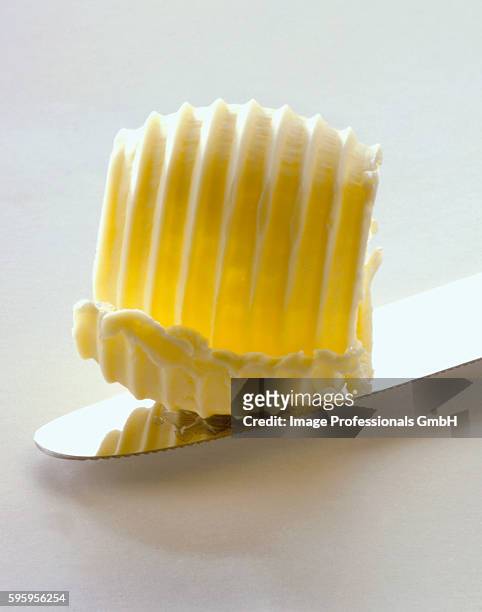 a butter curl on a knife (close-up) - butter curl stock pictures, royalty-free photos & images