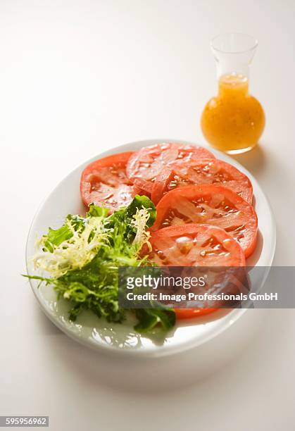 sliced tomatoes with greens; salad dressing - curly endive stock pictures, royalty-free photos & images