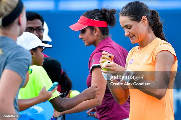 Sania Mirza of India and Monica Niculescu of Romania sign autographs after defeating Andreja Klepac of Slovenia and Katarina Srebotnik of Slovenia on...
