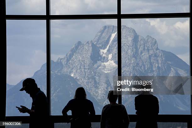 The silhouette of people standing in front of a window in the lobby area of the Jackson Lake Lodge is seen during the Jackson Hole economic...