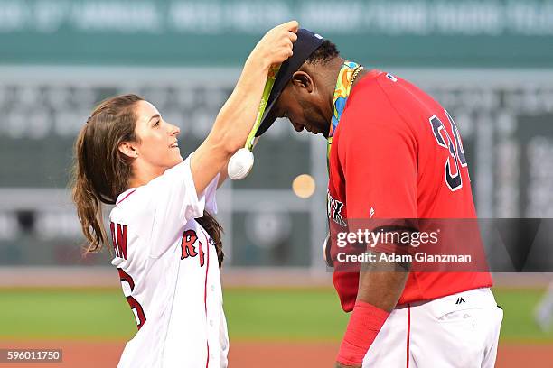 Olympic gymnast Aly Raisman puts a medal on David Ortiz of the Boston Red Sox before throwing out a ceremonial first pitch before a game against the...