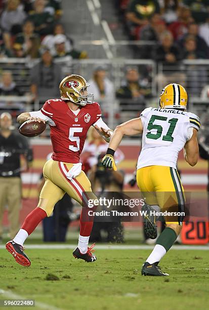 Christian Ponder of the San Francisco 49ers looks to get his pass off under pressure from outside linebacker Kyler Fackrell of the Green Bay Packers...