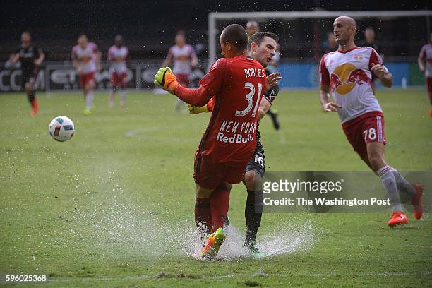 United forward Patrick Mullins collides with New York Red Bulls goalkeeper Luis Robles in the first half of the after a rain delay August 21, 2016 in...