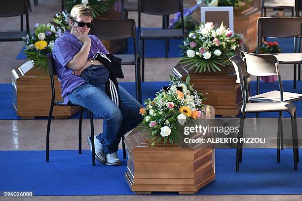 Women mourns next to the coffin of an earthquake victim, in a gymnasium arranged in a chapel of rest on August 27 in Ascoli Piceno, three days after...