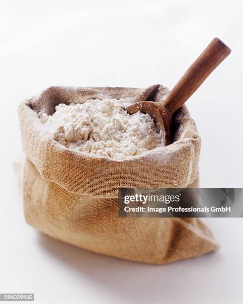 a sack of flour with wooden scoop - flour bag stockfoto's en -beelden