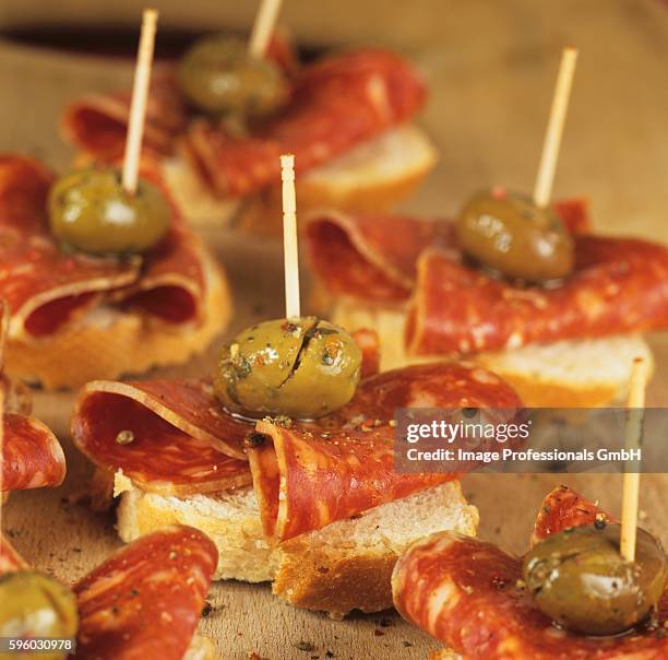 canap??s with chorizo and green olives - canap�� stock-fotos und bilder