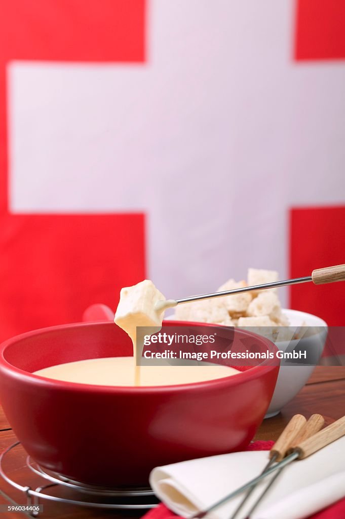 Cheese fondue in front of Swiss flag