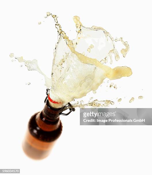 beer splashing out of brown bottle - beer splash stock pictures, royalty-free photos & images