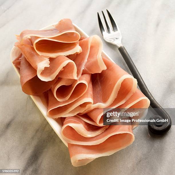 jamon serrano ham on a dish, fork - serrano ham foto e immagini stock