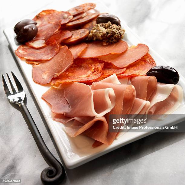 tapas platter with jamon serrano, pamploma, lomo, soria, picante sausage and black olives - jamon serrano photos et images de collection