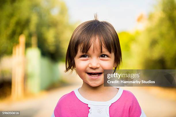 portrait of laughing baby girl looking away with content smile - eenjarig plantenkenmerk stockfoto's en -beelden