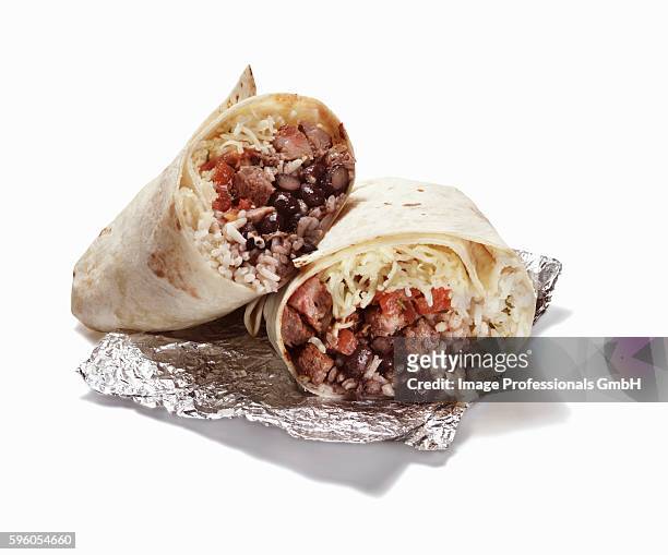 rice and bean burrito halved on foil - burrito stockfoto's en -beelden