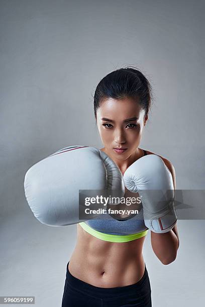 young woman in boxing gloves - women's boxing stock-fotos und bilder