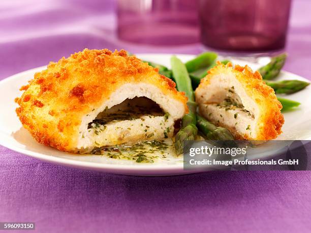 chicken kiev with garlic butter, herbs and asparagus - chicken kiev stock-fotos und bilder