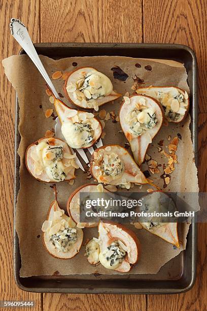 baked pears with blue cheese and slivered almonds - blauwschimmelkaas stockfoto's en -beelden
