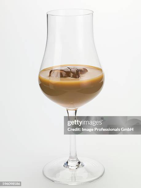 cream liqueur with ice cubes in a glass - baileys glass stock pictures, royalty-free photos & images