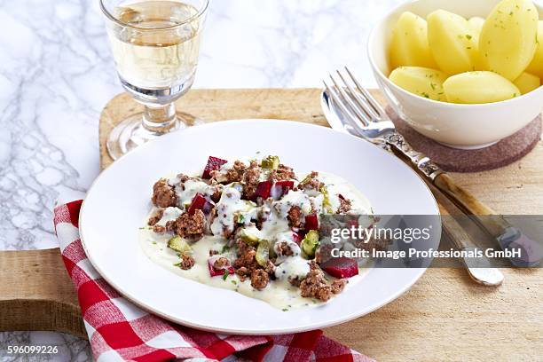 a dish of beetroot and minced meat served with boiled potatoes - ground beef stew stock-fotos und bilder