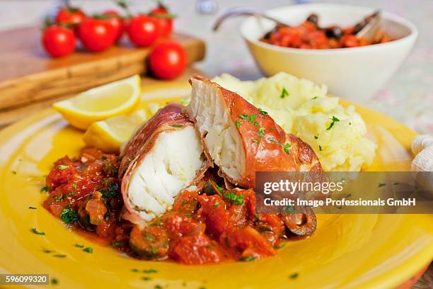 cod wrapped in prosciutto with tomato sauce - prosciutto wrapped stock pictures, royalty-free photos & images