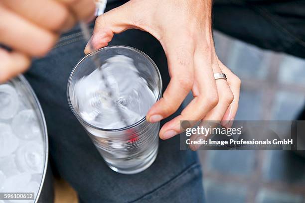 ice cubes being stirred in a glass - stirring stock-fotos und bilder