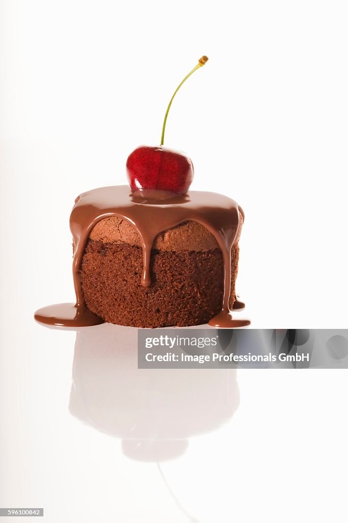 Individual Chocolate Dessert with Chocolate Sauce and a Cherry; White Background