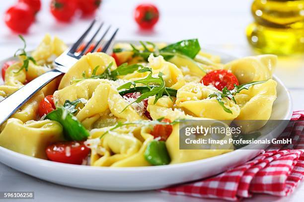 tortelloni with cherry tomatoes and rocket - tortelloni stock-fotos und bilder