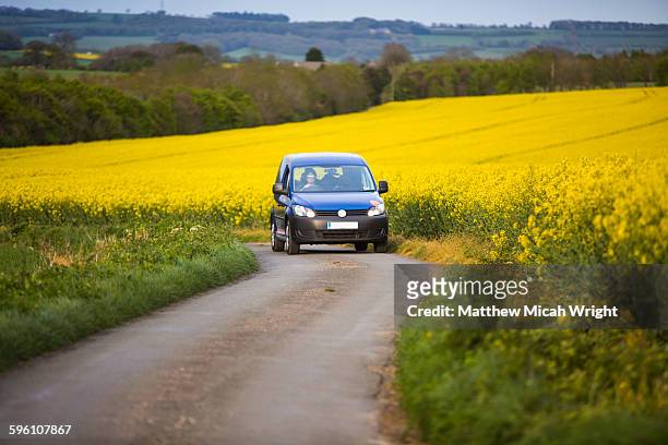 english countryside covered in yellow flowers. - car on road stock pictures, royalty-free photos & images