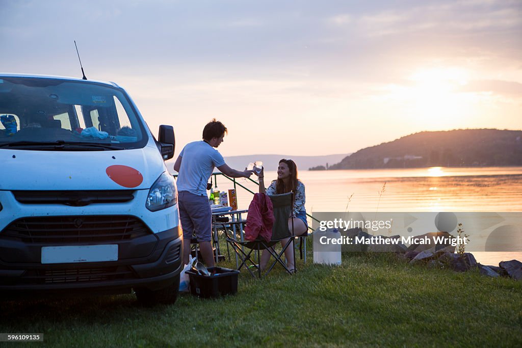 A sunset dinner at a lakeside campsite.