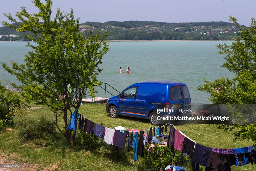 A couple wash clothes and bathe in a lake.