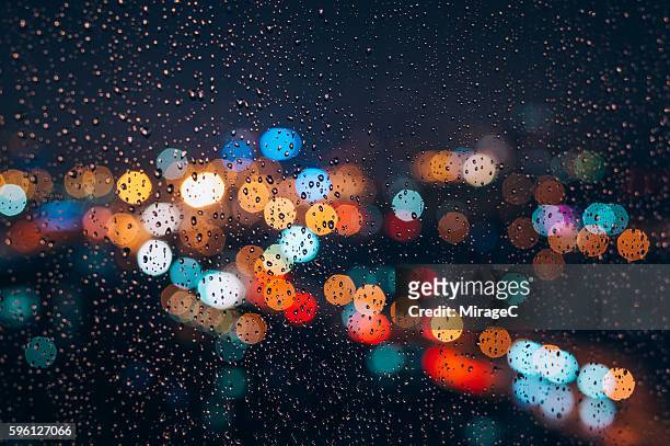 bokeh of city behind the rainy night window glass - africa abstract fotografías e imágenes de stock