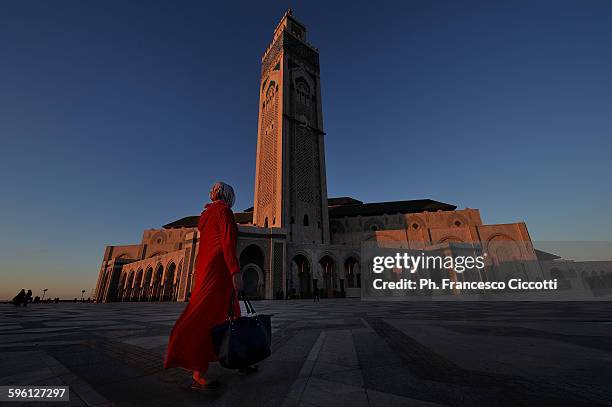 girl in red at hassan ii mosque - casablanca photos et images de collection