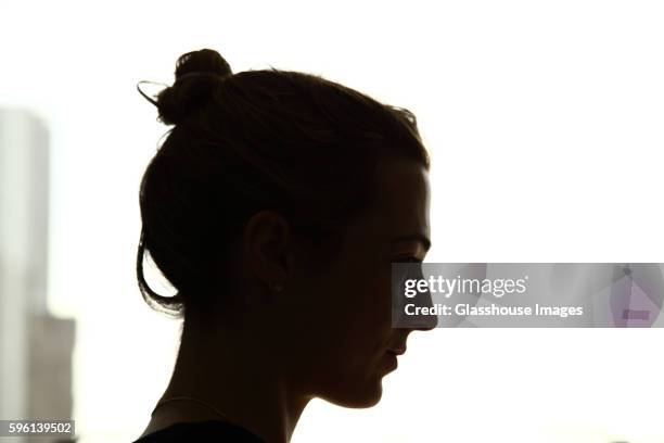 silhouette of serious young woman, profile - profile woman silhouette stock-fotos und bilder