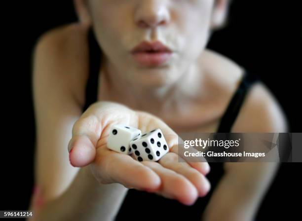 woman blowing on dice - dice stock pictures, royalty-free photos & images