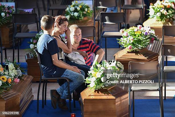 Relatives mourn next to the coffin of an earthquake victim, in a gymnasium arranged in a chapel of rest on August 27 in Ascoli Piceno, three days...