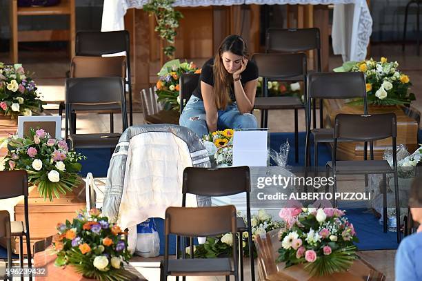 Woman mourns next to the coffin of an earthquake victim, in a gymnasium arranged in a chapel of rest on August 27 in Ascoli Piceno, three days after...
