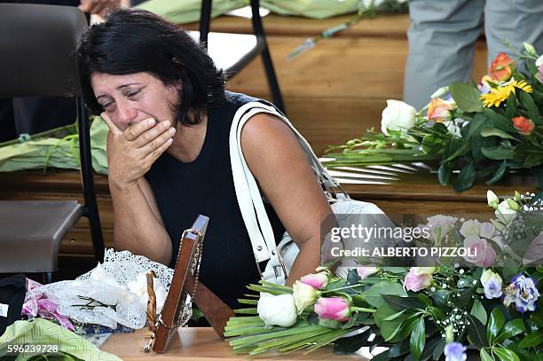 Women mourns next to the coffin of an earthquake victim, in a gymnasium arranged in a chapel of rest on August 27 in Ascoli Piceno, three days after...