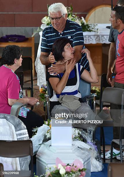 Relatives mourn next to the coffin of an earthquake victim, in a gymnasium arranged in a chapel of rest on August 27 in Ascoli Piceno, three days...