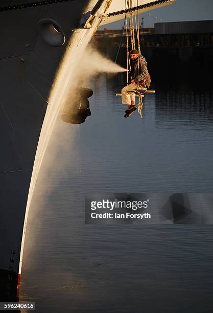 Crew member washes the hull of the Polish ship, Dar Mlodziezy during the North Sea Tall Ships Regatta on August 27, 2016 in Blyth, England. The...