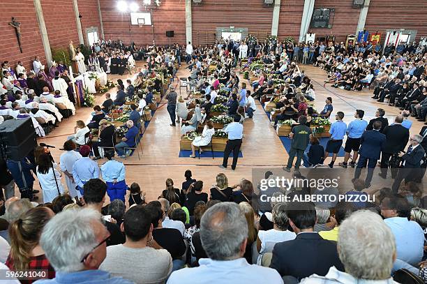 People attend a funeral service for victims of the earthquake, at a gymnasium arranged in a chapel of rest on August 27 in Ascoli Piceno, three days...