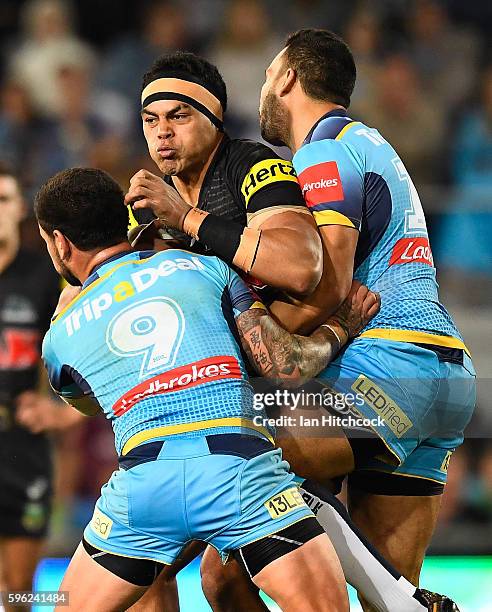 Sitaleki Akauola of the Panthers is tackled by Nathan Peats of the Titans during the round 25 NRL match between the Gold Coast Titans and the Penrith...