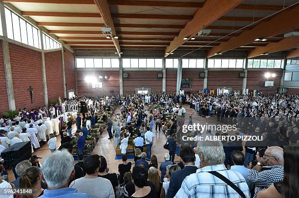 People gather during a funeral service for victims of the earthquake, at a gymnasium arranged in a chapel of rest on August 27 in Ascoli Piceno,...