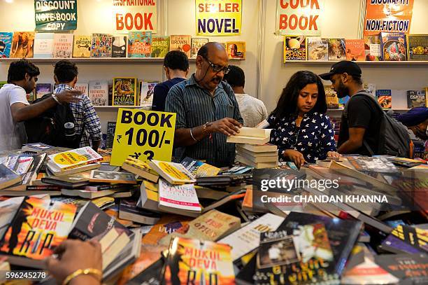 Indian visitors browse through books at the Delhi Book Fair at Pragati Maidan in New Delhi on August 27, 2016. / AFP / CHANDAN KHANNA