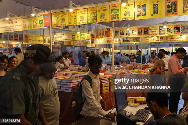 Indian visitors browse through books at the Delhi Book Fair at Pragati Maidan in New Delhi on August 27, 2016. / AFP / CHANDAN KHANNA