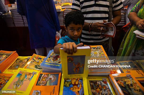 An Indian child browses through books at the Delhi Book Fair at Pragati Maidan in New Delhi on August 27, 2016. / AFP / CHANDAN KHANNA